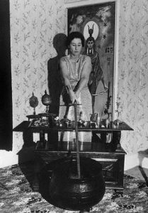 26 Sep 1964, London, England, UK --- Original caption: Against the backdrop of a painting of Isis, the Eqyptian mother goddess, Mrs. Eleanor Bone practices witchcraft in her London home, using traditional sword, cauldron, and assorted trinkets. She is one of the 5,000 practicing witches in Britain. --- Image by © Bettmann/CORBIS